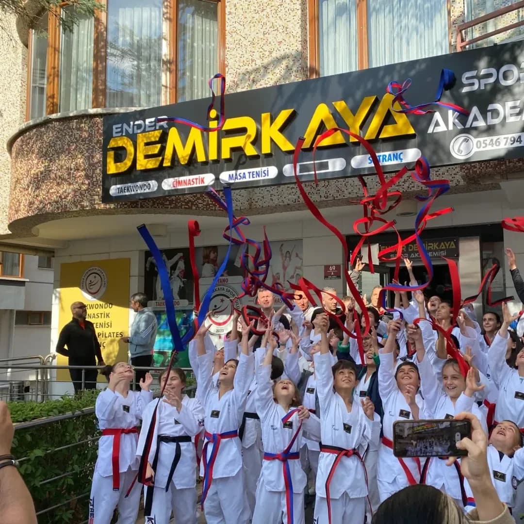Ender Demirkaya Spor Kulübü tabelası önünde sporcuların kuşak kutlaması